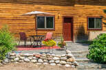 Enjoy outdoor living on this charming patio, complete with a table, chairs, and a large umbrella for shade.