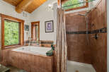 Experience tranquility in this rustic bathroom featuring a deep soaking tub surrounded by warm terracotta tiles and a separate shower with elegant tilework.