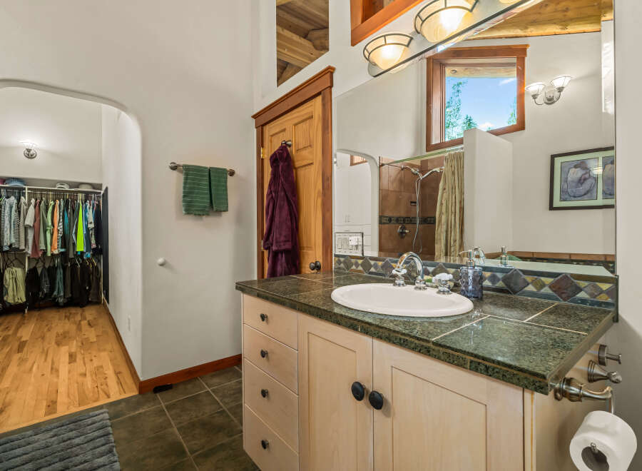 This charming bathroom features a spacious walk-in closet with ample storage for all your clothing needs.