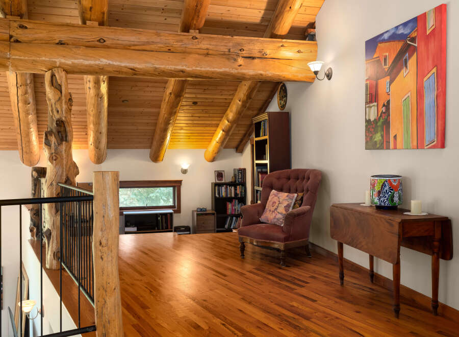 Experience rustic charm in this loft-style living space, featuring exposed wooden beams and a warm, inviting atmosphere.
