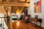 Experience rustic charm in this loft-style living space, featuring exposed wooden beams and a warm, inviting atmosphere.