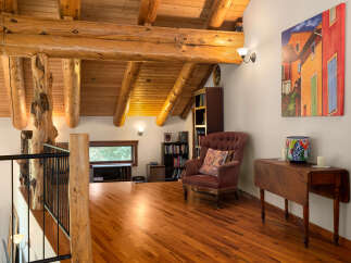 Experience rustic charm in this loft-style living space, featuring exposed wooden beams and a warm, inviting atmosphere.