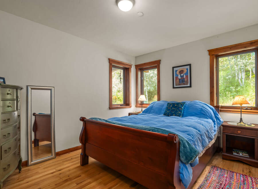 This charming bedroom features a cozy queen-size sleigh bed adorned with bright blue bedding and a decorative throw pillow.