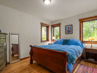 This charming bedroom features a cozy queen-size sleigh bed adorned with bright blue bedding and a decorative throw pillow.