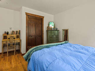 This charming bedroom features a cozy bed with a vibrant blue comforter, perfect for relaxation.