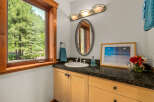 This charming bathroom features a spacious vanity with a granite countertop, a white porcelain sink, and elegant chrome fixtures.