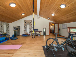 Transform your fitness routine in this dedicated home gym, featuring a professional cycling setup with a Cervelo bike on a trainer.
