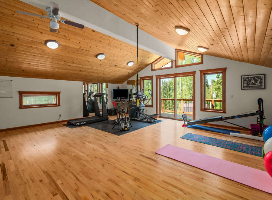 Transform your wellness routine in this spacious home gym, featuring a treadmill, elliptical, and stationary bike.