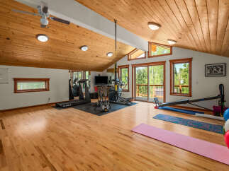 Transform your wellness routine in this spacious home gym, featuring a treadmill, elliptical, and stationary bike.
