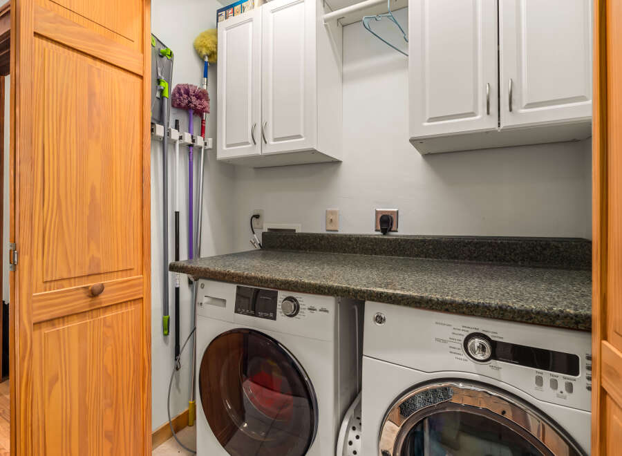 This laundry room features a stacked GE washer and dryer set, perfect for maximizing space.