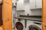 This laundry room features a stacked GE washer and dryer set, perfect for maximizing space.