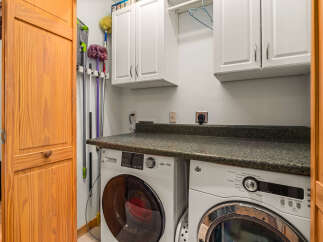 This laundry room features a stacked GE washer and dryer set, perfect for maximizing space.