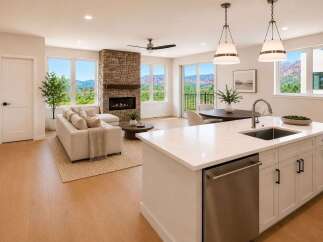 Experience luxurious living in this stunning open-concept home, featuring a modern kitchen with a large island and sleek cabinetry, flowing seamlessly into a spacious living area with a cozy stone fireplace.