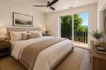 Experience serene living in this beautifully appointed bedroom, featuring a plush king-sized bed and a cozy throw blanket.