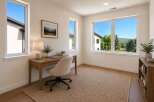 This home office features a spacious desk with a laptop and a comfortable office chair, perfect for remote work.