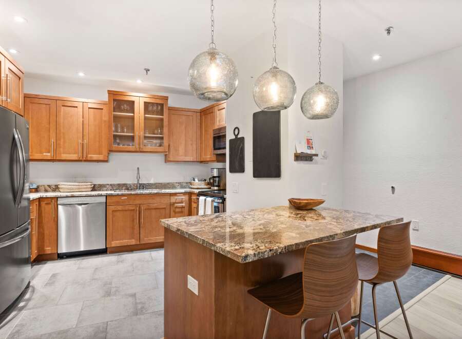 This modern kitchen boasts beautiful granite countertops and warm wood cabinetry, creating a sophisticated and inviting atmosphere.