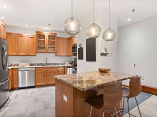 This modern kitchen boasts beautiful granite countertops and warm wood cabinetry, creating a sophisticated and inviting atmosphere.
