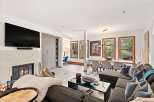 Experience modern living in this spacious open-concept home, featuring a cozy fireplace and a sleek wall-mounted TV.