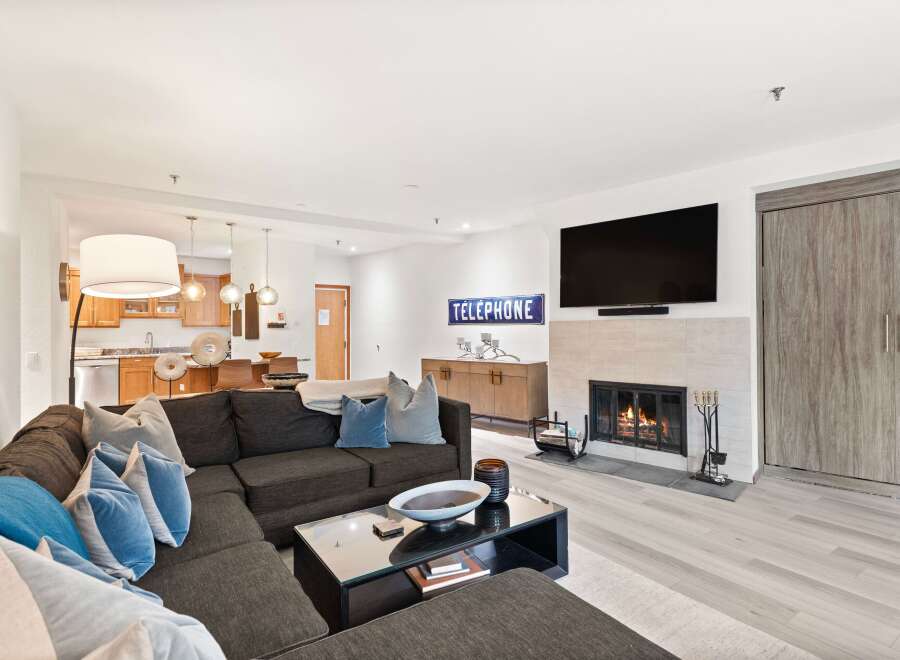 Experience modern living in this spacious living room featuring a cozy fireplace and a large sectional sofa perfect for gatherings.
