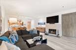 Experience modern living in this spacious living room featuring a cozy fireplace and a large sectional sofa perfect for gatherings.