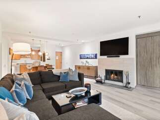 Experience modern living in this spacious living room featuring a cozy fireplace and a large sectional sofa perfect for gatherings.