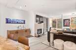 Experience modern living in this beautifully appointed living space, featuring a cozy fireplace and a stylish wooden credenza adorned with a unique candelabra.