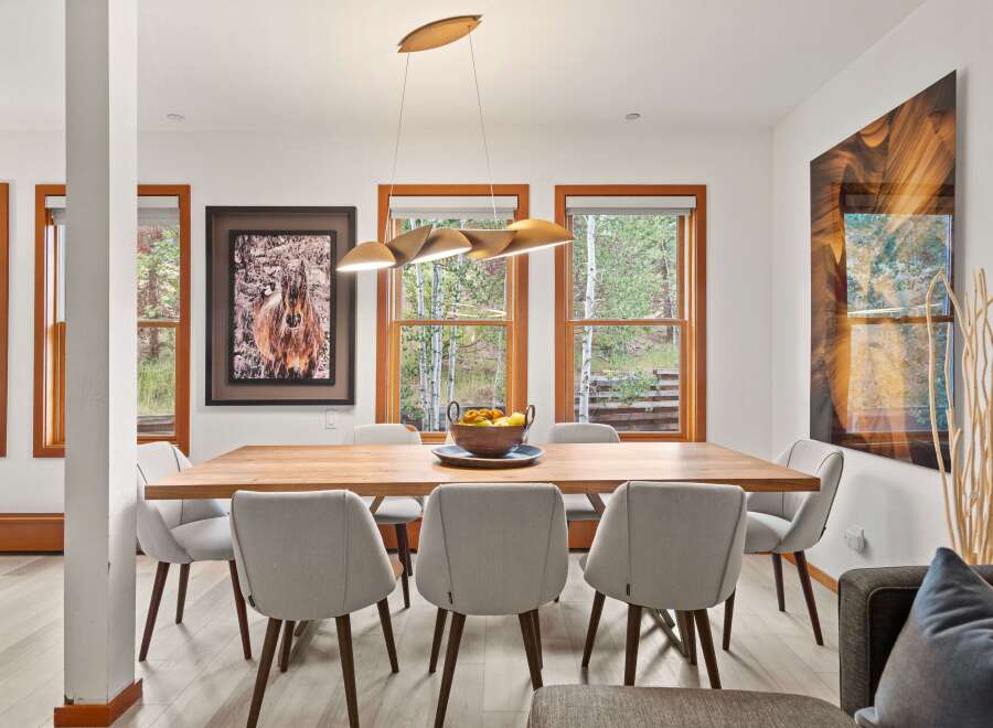 Experience elegant dining in this beautifully appointed space, featuring a sleek wooden table surrounded by comfortable upholstered chairs.