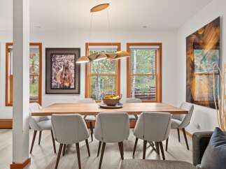 Experience elegant dining in this beautifully appointed space, featuring a sleek wooden table surrounded by comfortable upholstered chairs.