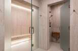 Experience ultimate relaxation in this luxurious spa-like bathroom featuring a spacious steam room with a built-in bench and ambient lighting.
