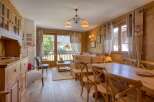 Experience cozy mountain living in this charming wooden chalet, featuring a spacious dining area with a large wooden table and chairs, perfect for family meals.