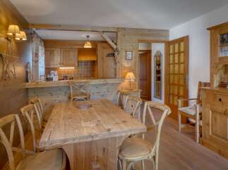 Experience rustic charm in this inviting dining area, featuring a solid wood table surrounded by classic cross-back chairs.