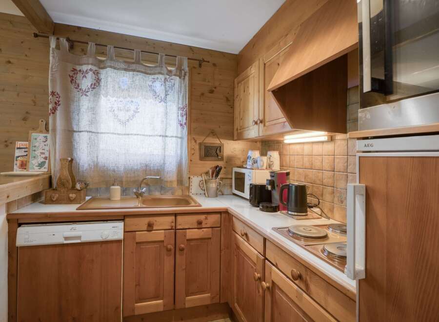This charming kitchen features warm wooden cabinetry and paneling, creating a cozy and rustic ambiance.
