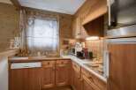 This charming kitchen features warm wooden cabinetry and paneling, creating a cozy and rustic ambiance.