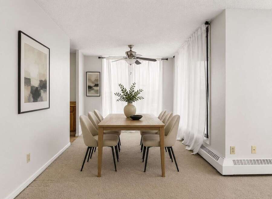 This dining room features a light wood dining table with six upholstered chairs, perfect for intimate gatherings.
