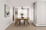 This dining room features a light wood dining table with six upholstered chairs, perfect for intimate gatherings.