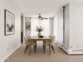 This dining room features a light wood dining table with six upholstered chairs, perfect for intimate gatherings.