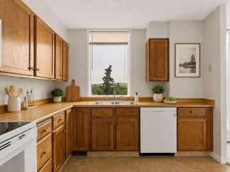 Discover this charming kitchen featuring warm oak cabinetry and durable laminate countertops.