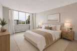 Experience comfortable living in this beautifully staged bedroom, featuring a plush king-size bed with crisp white linens and accent pillows.