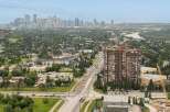 Experience city living with a touch of nature in this stunning high-rise apartment complex, offering breathtaking panoramic views of the city skyline and a lush, green landscape.