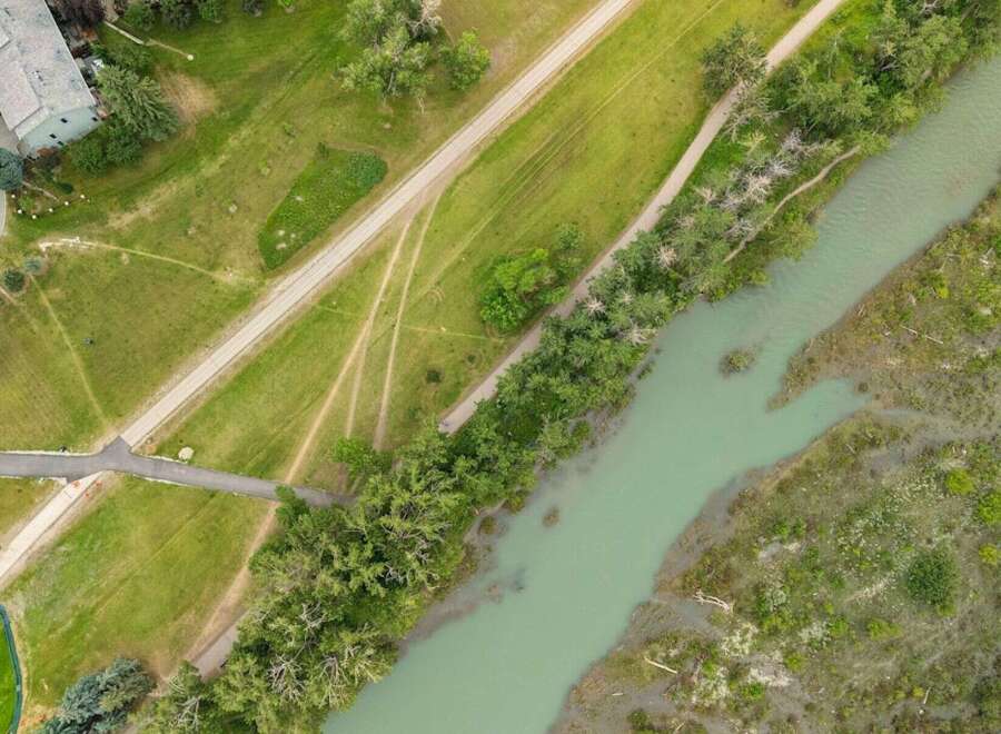 Discover this stunning aerial view showcasing a serene riverfront property, perfect for those seeking a blend of nature and accessibility.