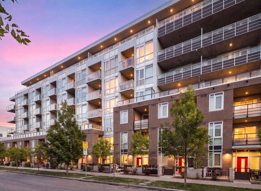 Experience modern urban living in this stunning multi-story apartment building, featuring sleek architecture and private balconies perfect for enjoying the twilight sky.