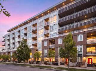 Experience modern urban living in this stunning multi-story apartment building, featuring sleek architecture and private balconies perfect for enjoying the twilight sky.