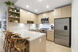 Experience modern living in this stunning kitchen, featuring sleek light wood cabinetry and a spacious quartz island perfect for entertaining.