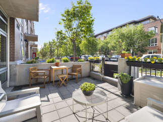 Enjoy outdoor living on this charming patio featuring comfortable seating and a dining set perfect for al fresco meals.