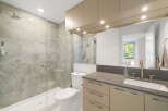 Experience modern luxury in this stunning bathroom featuring a spacious walk-in shower with elegant marble-look tiles and a sleek glass enclosure.
