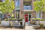 Discover modern urban living in this stunning condo featuring a vibrant red front door and a private patio area perfect for outdoor relaxation.
