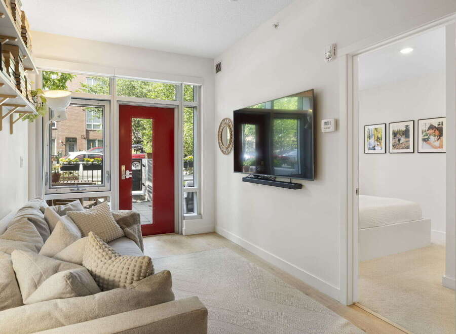 Step into this inviting living space featuring a comfortable sofa adorned with plush pillows, perfect for relaxation.