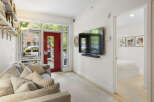 Step into this inviting living space featuring a comfortable sofa adorned with plush pillows, perfect for relaxation.