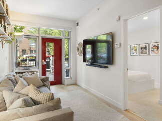 Step into this inviting living space featuring a comfortable sofa adorned with plush pillows, perfect for relaxation.