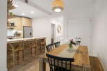 This modern dining area features a spacious wooden table with black chairs, perfect for family meals.
